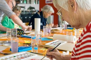group of older adults painting with watercolor